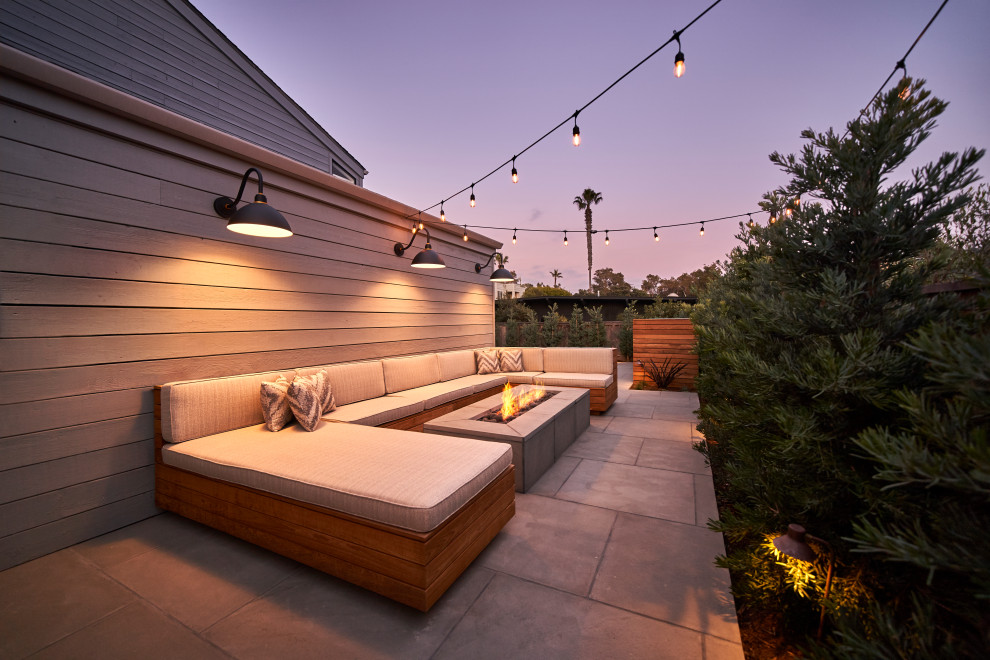 Immagine di un piccolo patio o portico contemporaneo dietro casa con un focolare, pavimentazioni in pietra naturale e nessuna copertura