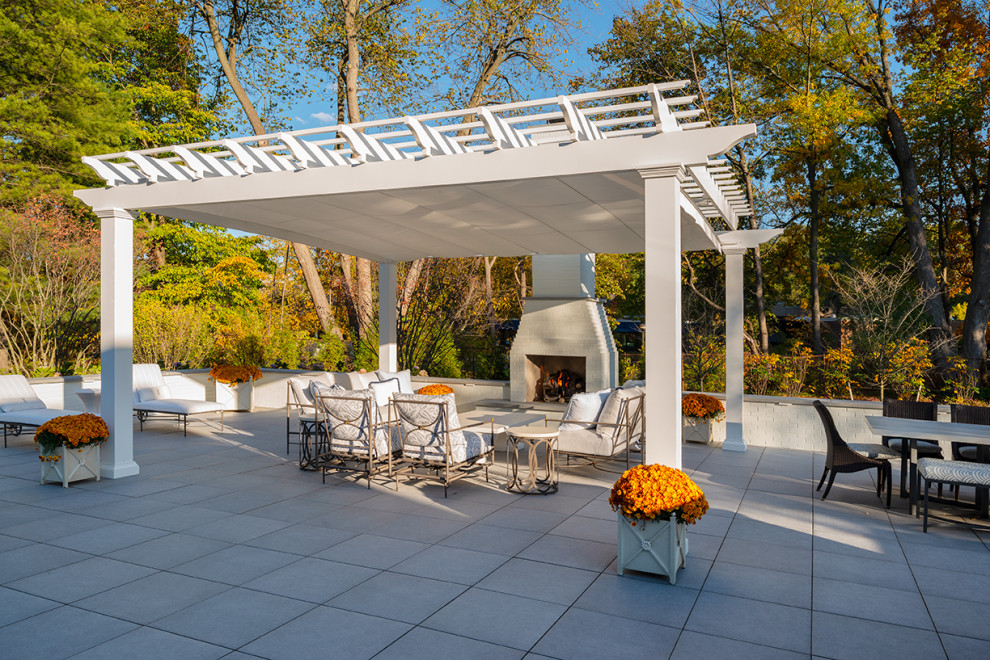 Esempio di un ampio patio o portico minimalista dietro casa con pavimentazioni in cemento e una pergola