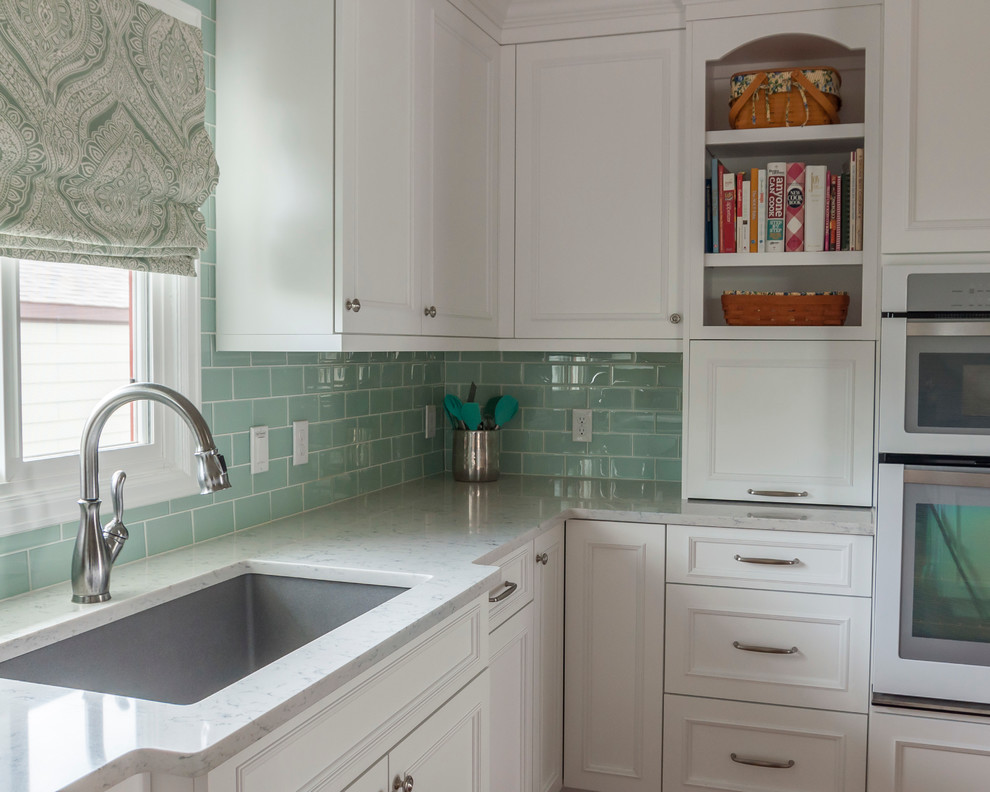 Example of a mid-sized transitional medium tone wood floor eat-in kitchen design in Denver with a single-bowl sink, flat-panel cabinets, yellow cabinets, quartz countertops, blue backsplash, glass tile backsplash, white appliances and an island
