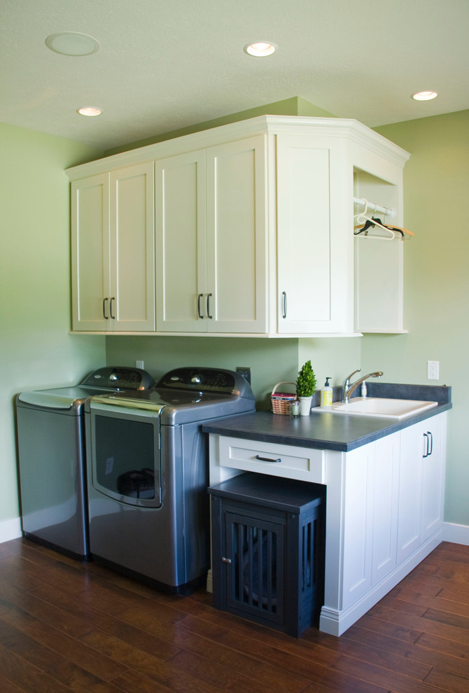 Design ideas for a large country laundry room in Other with a drop-in sink, shaker cabinets, white cabinets, laminate benchtops, green walls, medium hardwood floors and a side-by-side washer and dryer.