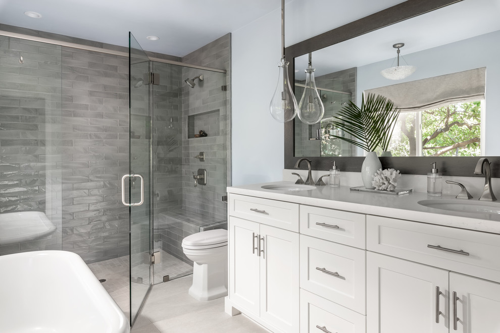 Design ideas for a mid-sized beach style master bathroom in Sacramento with shaker cabinets, white cabinets, gray tile, blue walls, beige floor, a hinged shower door, a curbless shower and an undermount sink.