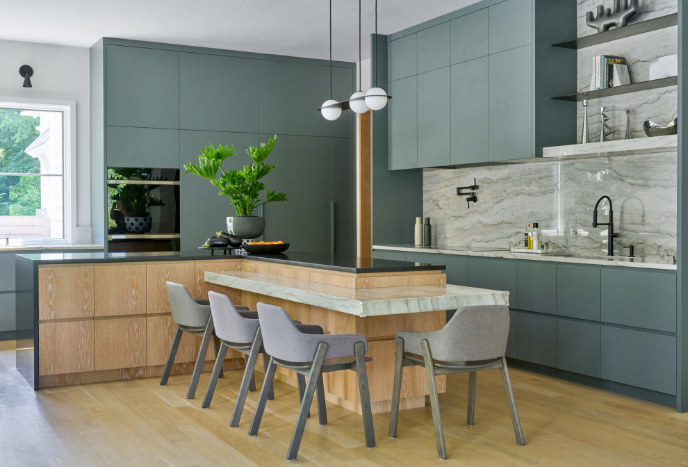 Inspiration for a contemporary l-shaped open plan kitchen in New York with an undermount sink, flat-panel cabinets, green cabinets, marble benchtops, multi-coloured splashback, marble splashback, black appliances, medium hardwood floors, with island, brown floor and multi-coloured benchtop.
