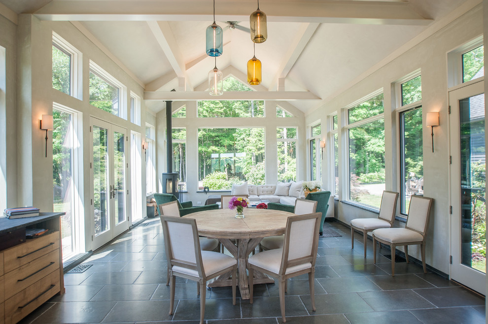 Inspiration for a large country sunroom in Boston with porcelain floors, a metal fireplace surround, a standard ceiling, grey floor and a wood stove.