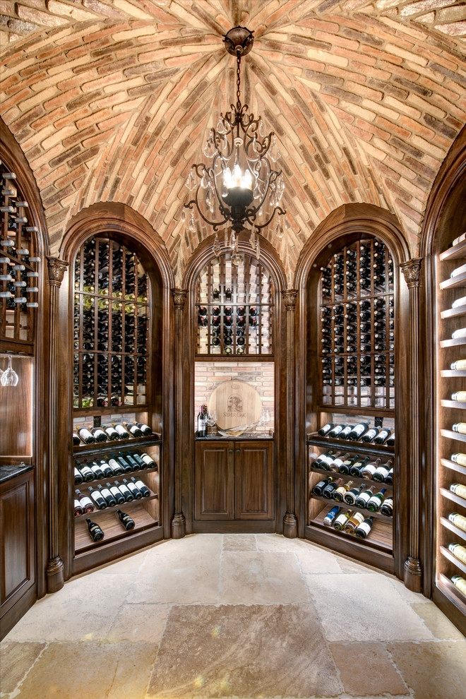 Design ideas for a mediterranean wine cellar with travertine floors, display racks and beige floor.