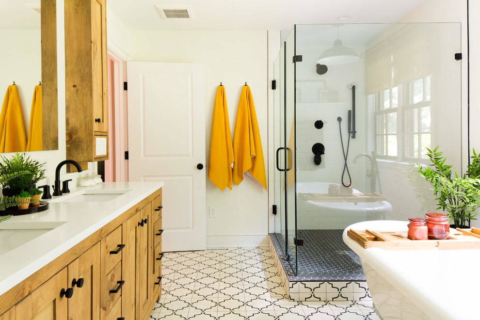 Inspiration for a transitional bathroom in Bridgeport with shaker cabinets, medium wood cabinets, a claw-foot tub, a corner shower, white tile, subway tile, white walls, an undermount sink, white floor, a hinged shower door and white benchtops.