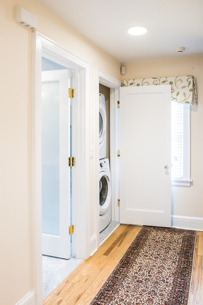 Design ideas for a mid-sized transitional laundry room in New York with recessed-panel cabinets, blue walls and grey floor.