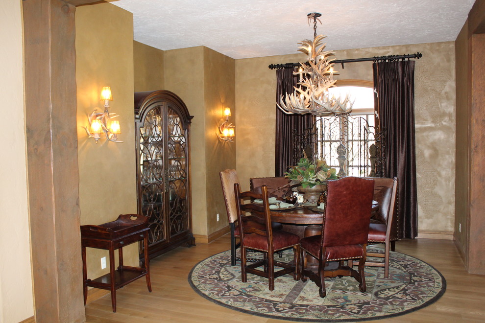 Example of a mid-sized mountain style light wood floor and brown floor enclosed dining room design with brown walls and no fireplace