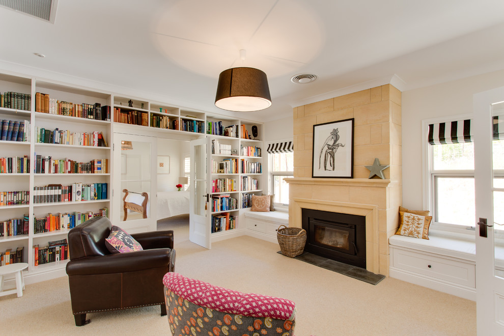 Mid-sized traditional enclosed living room in Adelaide with a library, white walls, carpet, a wood stove, a stone fireplace surround and no tv.