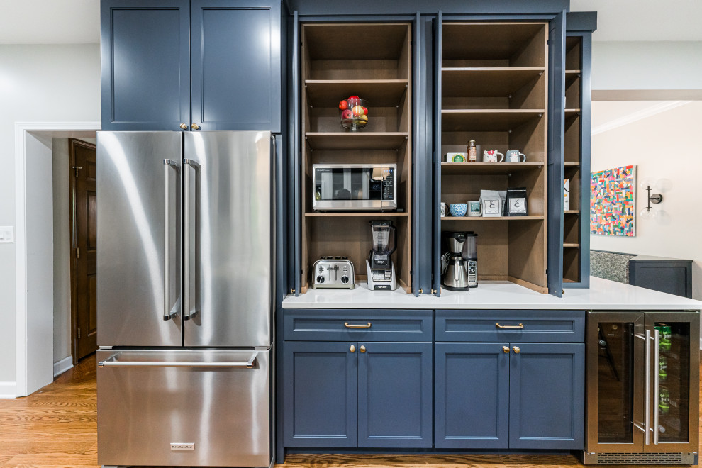 Example of a large transitional u-shaped medium tone wood floor and brown floor eat-in kitchen design in Chicago with a double-bowl sink, shaker cabinets, blue cabinets, quartzite countertops, white backsplash, mosaic tile backsplash, stainless steel appliances, an island and white countertops