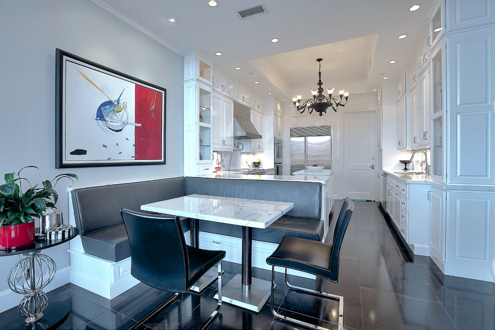 Inspiration for a transitional u-shaped eat-in kitchen in New York with raised-panel cabinets, white cabinets, white splashback, stainless steel appliances and black floor.