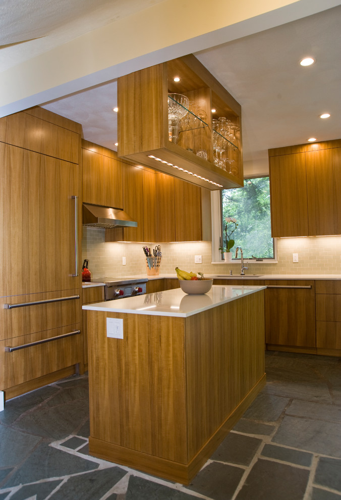 Photo of a mid-sized modern l-shaped kitchen pantry in Boston with an undermount sink, flat-panel cabinets, medium wood cabinets, quartz benchtops, green splashback, ceramic splashback, panelled appliances, slate floors, with island, grey floor and white benchtop.