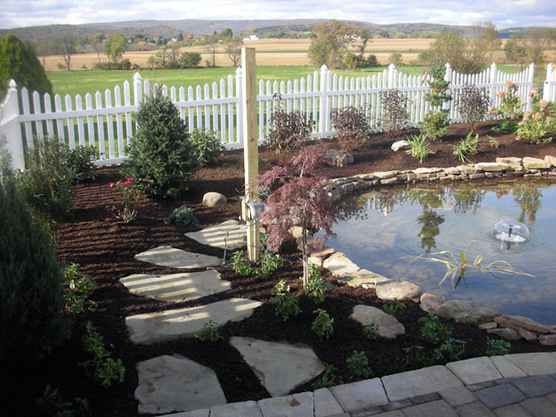 Photo of a backyard mulch water fountain landscape.