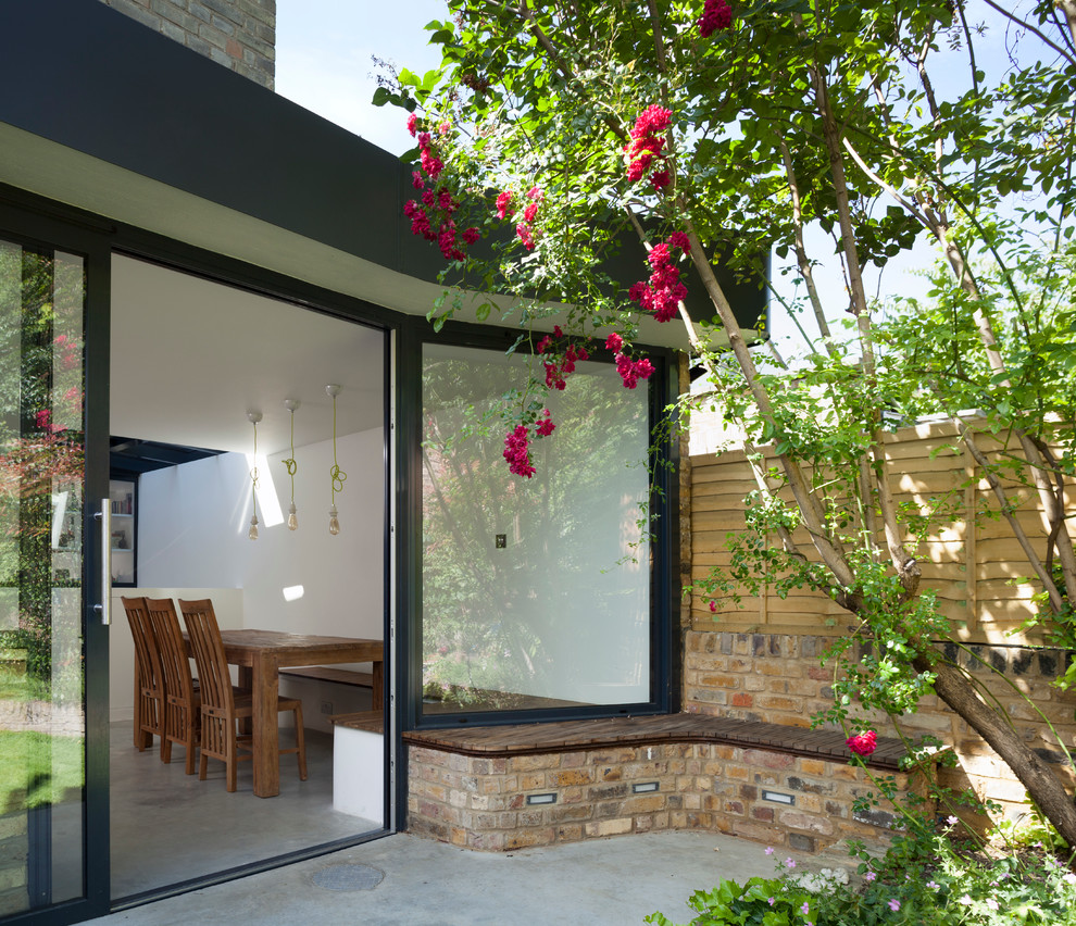 Inspiration for a contemporary backyard garden in London with concrete pavers.