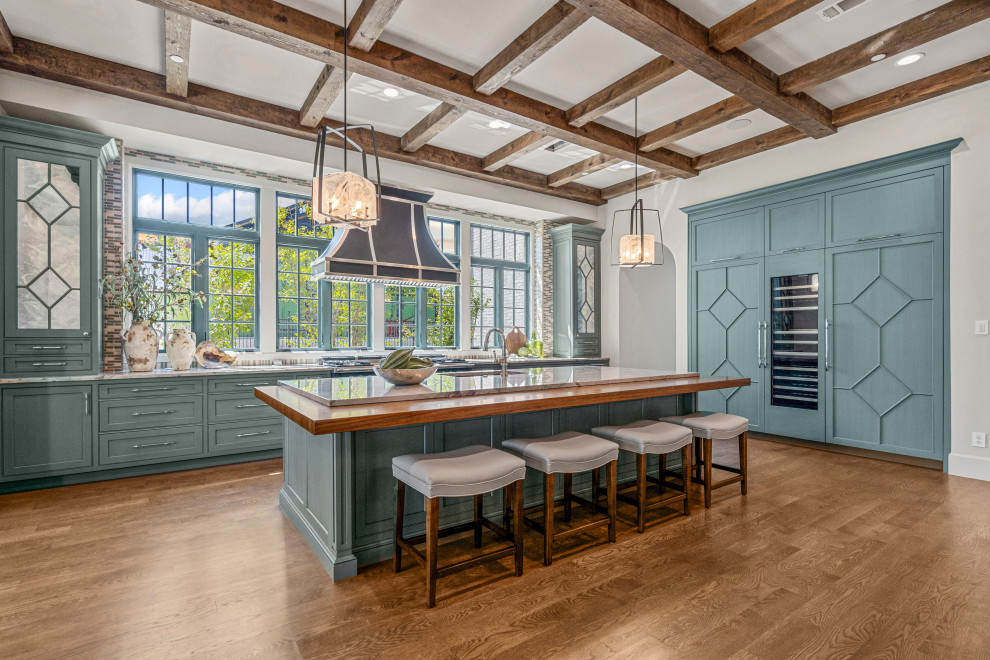 Bild på ett mycket stort vintage grå grått kök, med en undermonterad diskho, luckor med infälld panel, blå skåp, bänkskiva i kvarts, stänkskydd i trä, färgglada vitvaror, mellanmörkt trägolv och en köksö
