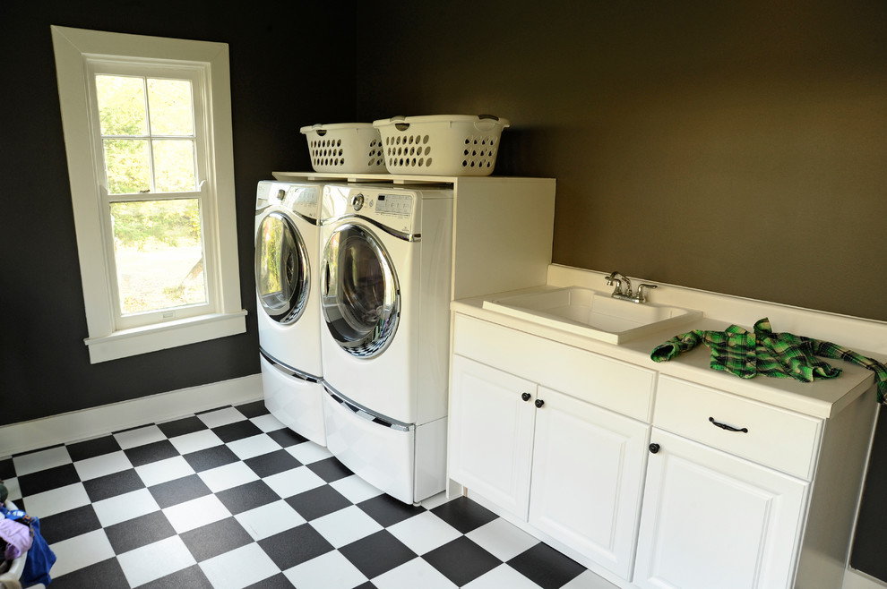 Large traditional single-wall utility room in Other with an utility sink, raised-panel cabinets, white cabinets, laminate benchtops, porcelain floors, a side-by-side washer and dryer and brown walls.