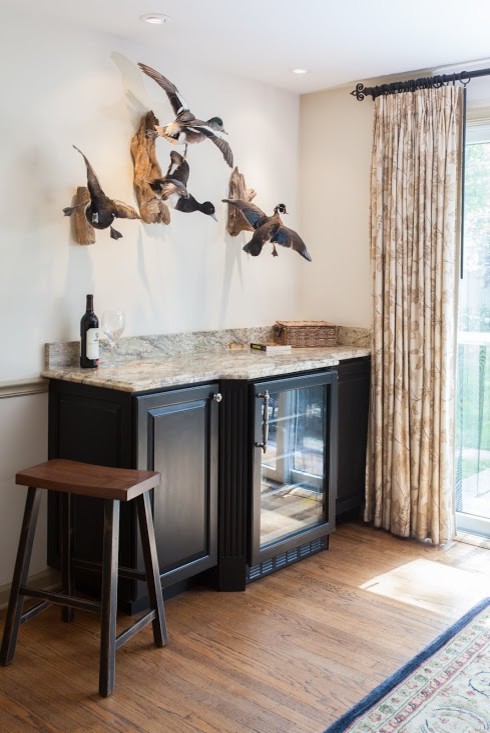 Small transitional single-wall home bar in Philadelphia with raised-panel cabinets, dark wood cabinets, granite benchtops and medium hardwood floors.
