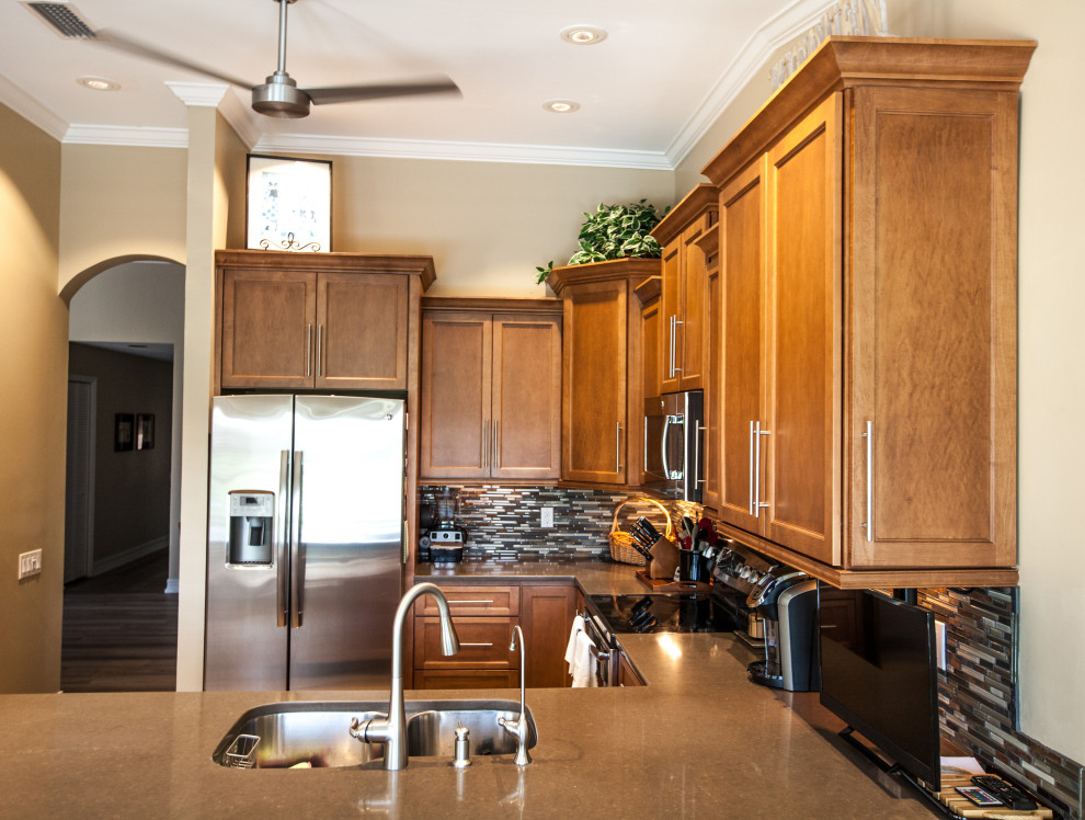 Inspiration for a mid-sized u-shaped ceramic tile kitchen remodel with an undermount sink, shaker cabinets, brown cabinets, wood countertops, mosaic tile backsplash, stainless steel appliances and brown countertops
