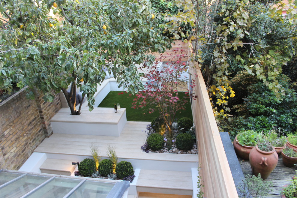 This is an example of a small contemporary backyard partial sun garden in London with decking.