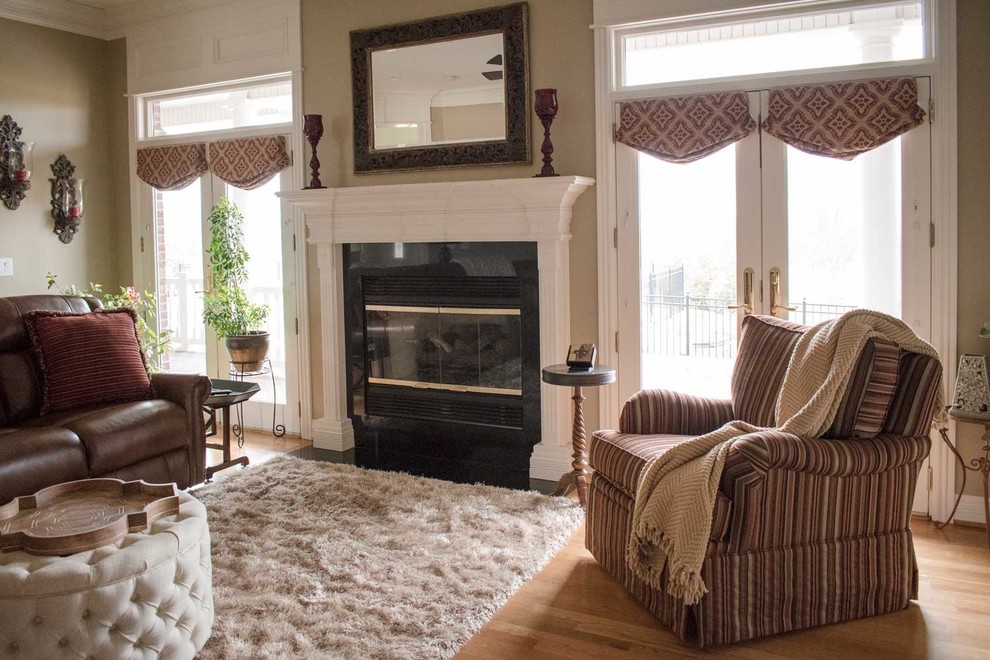 This is an example of a large traditional enclosed living room in Louisville with beige walls, light hardwood floors, a standard fireplace, a stone fireplace surround and a built-in media wall.