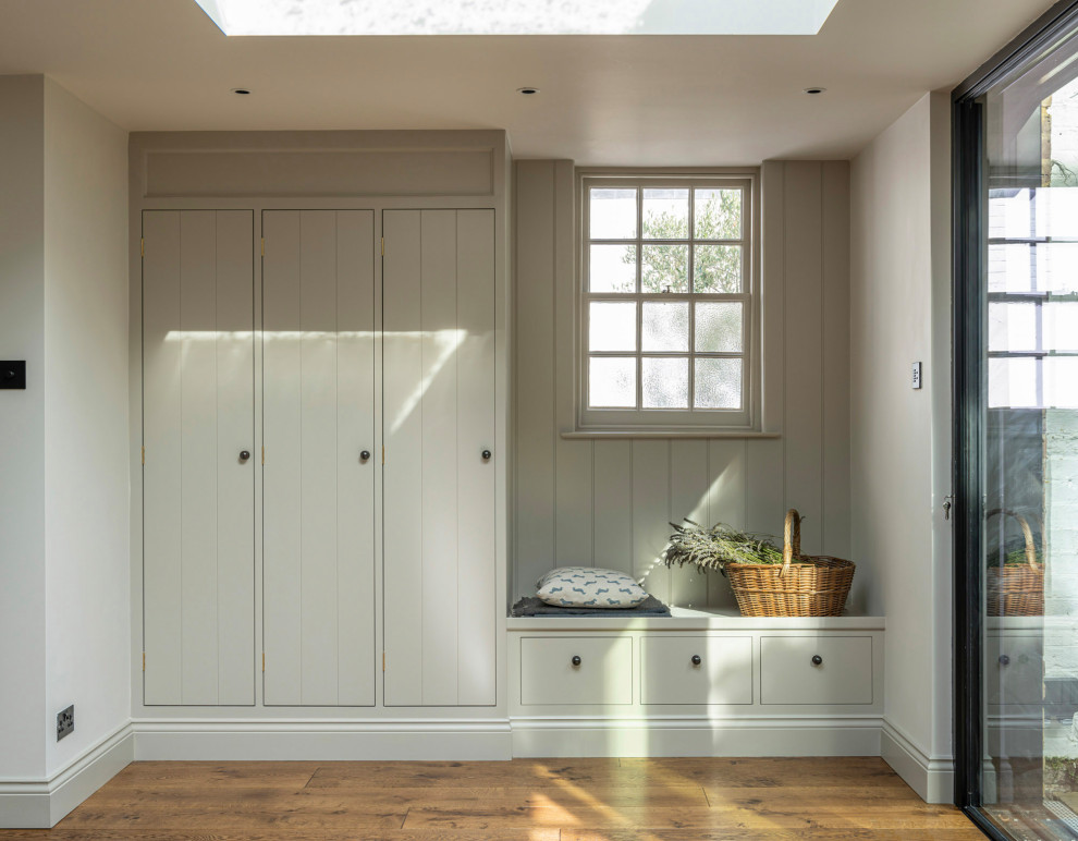 Design ideas for a transitional hallway in Buckinghamshire with medium hardwood floors, grey walls, brown floor and planked wall panelling.