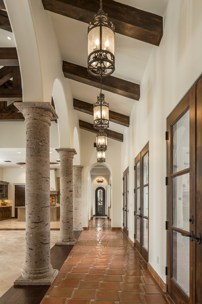 Mid-sized mediterranean hallway in Phoenix with white walls and terra-cotta floors.