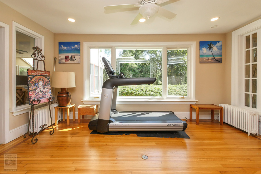 Design ideas for a mid-sized home gym in New York with beige walls, medium hardwood floors and brown floor.