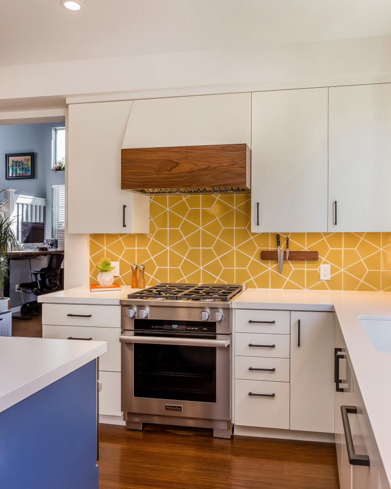Inspiration for a mid-sized 1950s u-shaped medium tone wood floor, brown floor and shiplap ceiling eat-in kitchen remodel in San Francisco with an undermount sink, flat-panel cabinets, white cabinets, quartz countertops, yellow backsplash, ceramic backsplash, stainless steel appliances, an island and white countertops