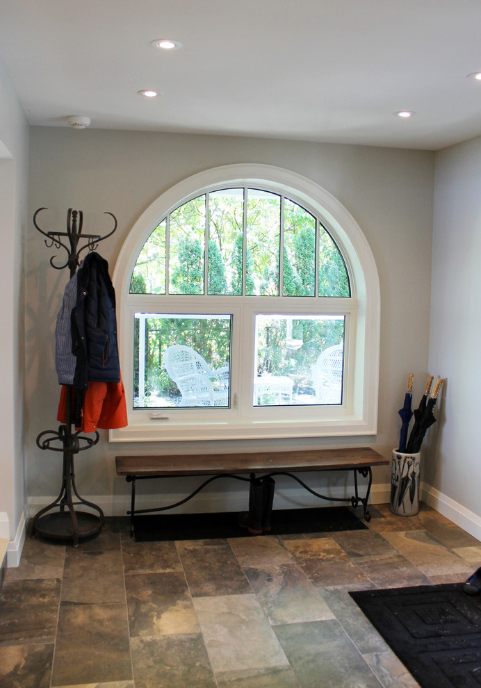 Photo of a beach style foyer in Toronto with grey walls, slate floors and a white front door.