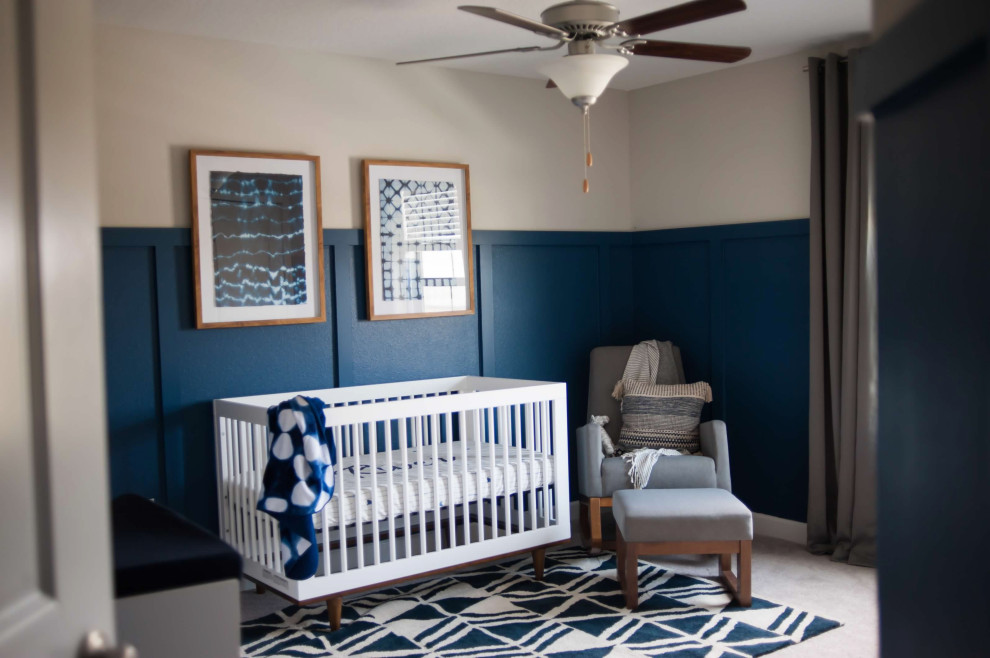 Immagine di una cameretta per neonato di medie dimensioni con pareti blu, moquette, pavimento beige e boiserie