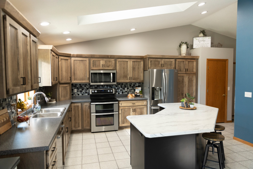 Example of a mid-sized transitional l-shaped eat-in kitchen design with shaker cabinets, laminate countertops and an island