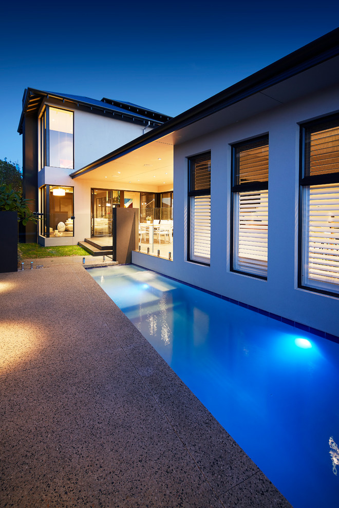 Inspiration for a small contemporary side yard rectangular lap pool in Other with concrete slab.