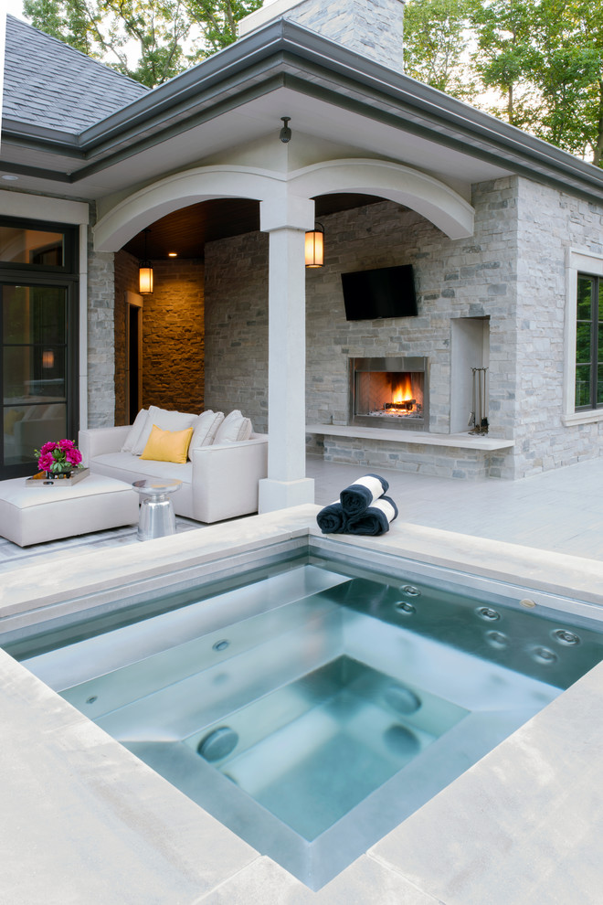 Design ideas for a large mediterranean backyard deck in Milwaukee with with fireplace and a roof extension.