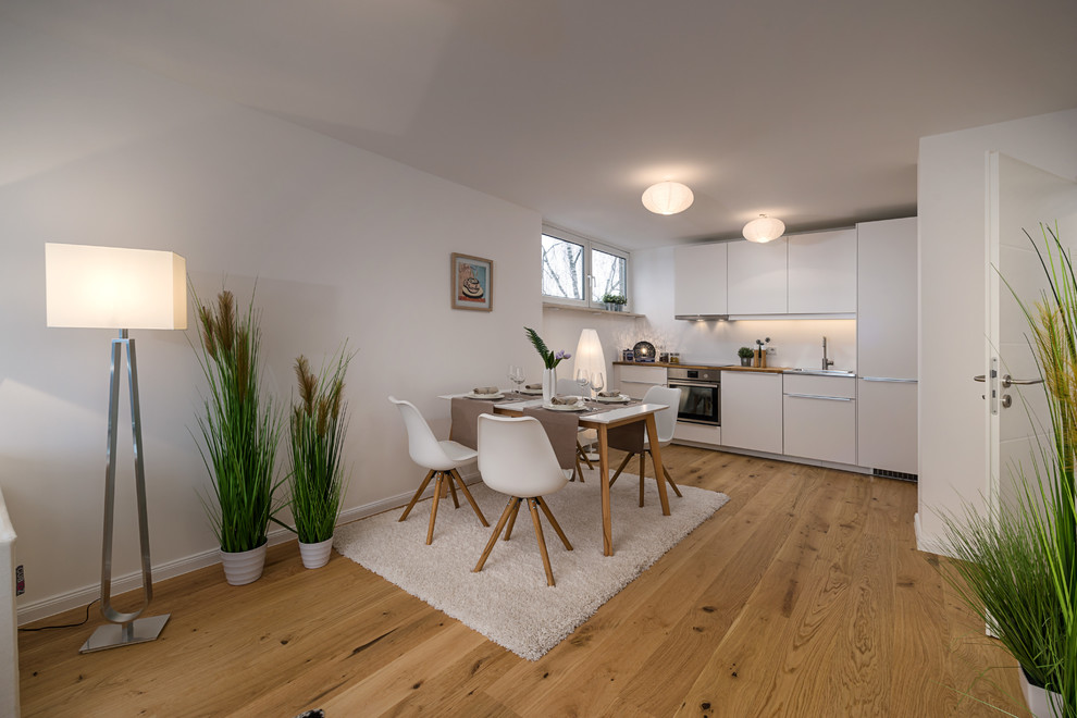 Mid-sized scandinavian open plan dining in Munich with white walls, medium hardwood floors, no fireplace and brown floor.