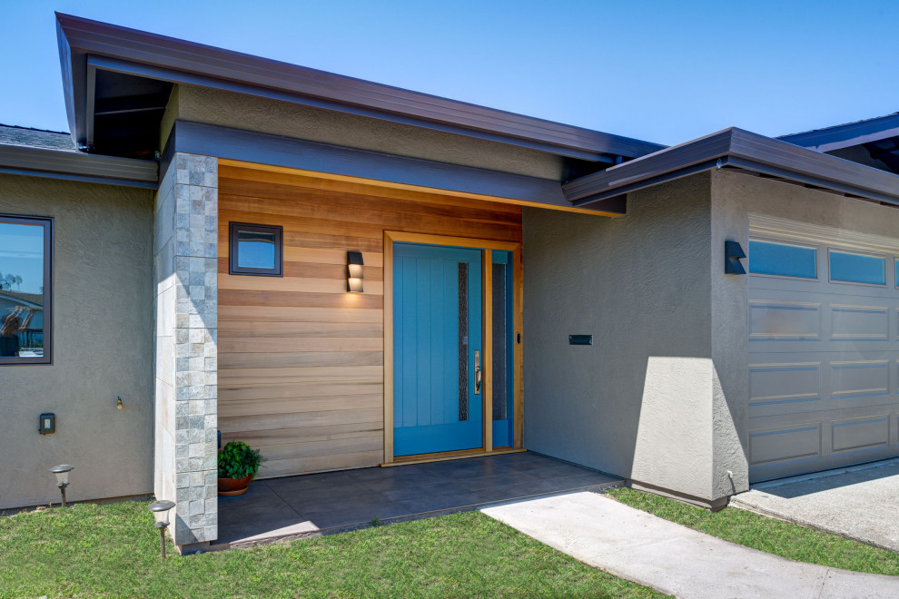 Стильный дизайн: входная дверь в стиле ретро с поворотной входной дверью, синей входной дверью и деревянными стенами - последний тренд