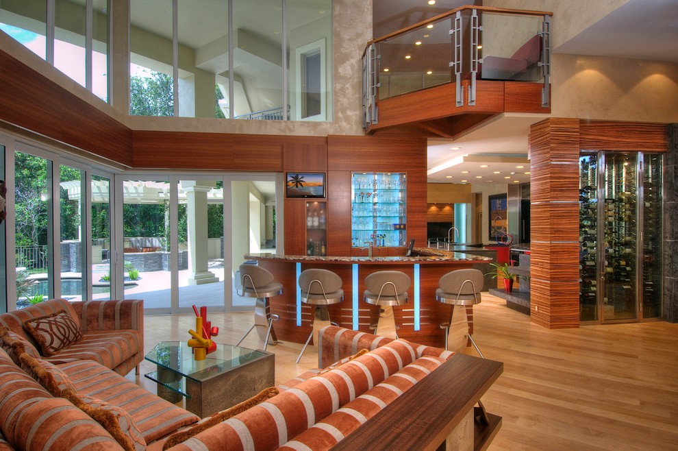 This is an example of a mid-sized contemporary open concept living room in Tampa with a home bar, brown walls, light hardwood floors and a built-in media wall.