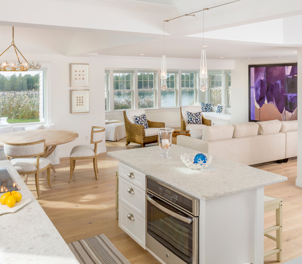 Design ideas for a mid-sized beach style open plan dining in Providence with white walls and light hardwood floors.