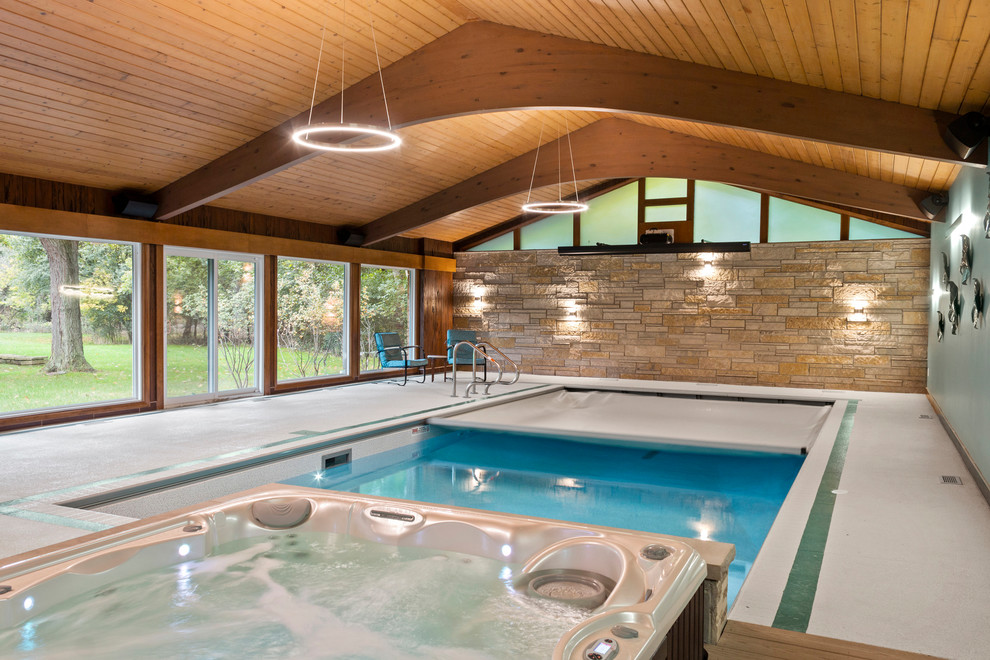 Design ideas for a small midcentury indoor rectangular pool in Milwaukee with a hot tub and concrete slab.