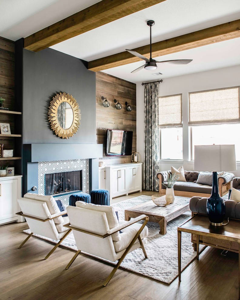 This is an example of a mid-sized transitional enclosed living room in Austin with multi-coloured walls, medium hardwood floors, a standard fireplace, a metal fireplace surround, a wall-mounted tv and beige floor.