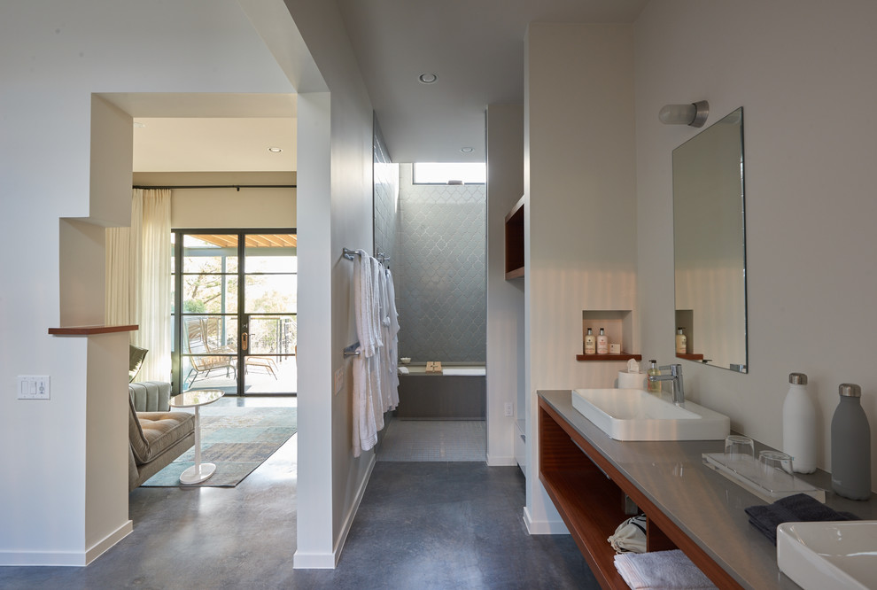 Photo of a mid-sized modern master bathroom in Austin with open cabinets, medium wood cabinets, an undermount tub, an open shower, gray tile, ceramic tile, white walls, concrete floors, a vessel sink, engineered quartz benchtops, beige floor and an open shower.