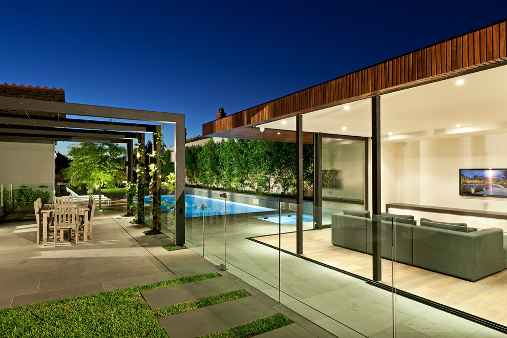 Inspiration for a modern backyard partial sun formal garden in Melbourne with natural stone pavers.