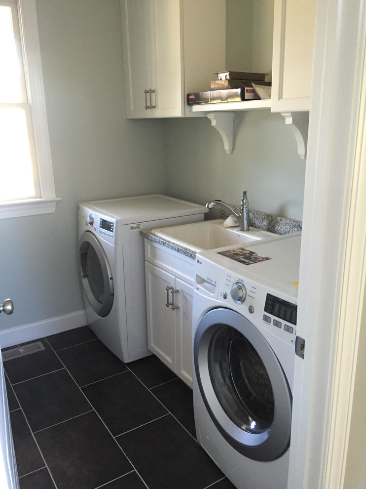 Photo of a mid-sized country single-wall dedicated laundry room in Charlotte with a drop-in sink, flat-panel cabinets, white cabinets, granite benchtops, grey walls, porcelain floors and a side-by-side washer and dryer.