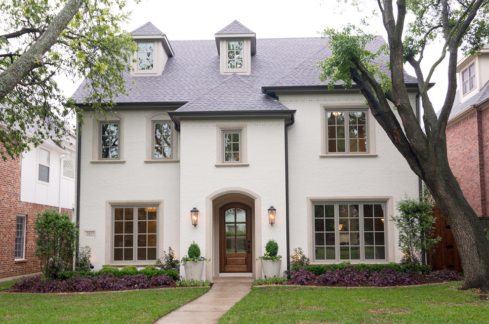 Mid-sized traditional white three-story brick exterior home idea in Dallas