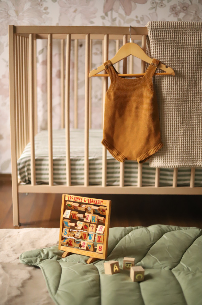 Diseño de habitación de bebé niña vintage de tamaño medio con paredes rosas, suelo de madera en tonos medios, suelo marrón y papel pintado