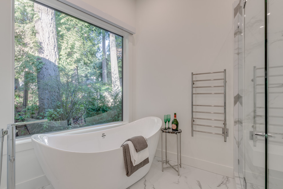Inspiration for a modern master bathroom in Vancouver with glass-front cabinets, white cabinets, a freestanding tub, an open shower, white tile, stone tile, white walls, marble floors, a vessel sink, engineered quartz benchtops, white floor, a hinged shower door, white benchtops and a wall-mount toilet.