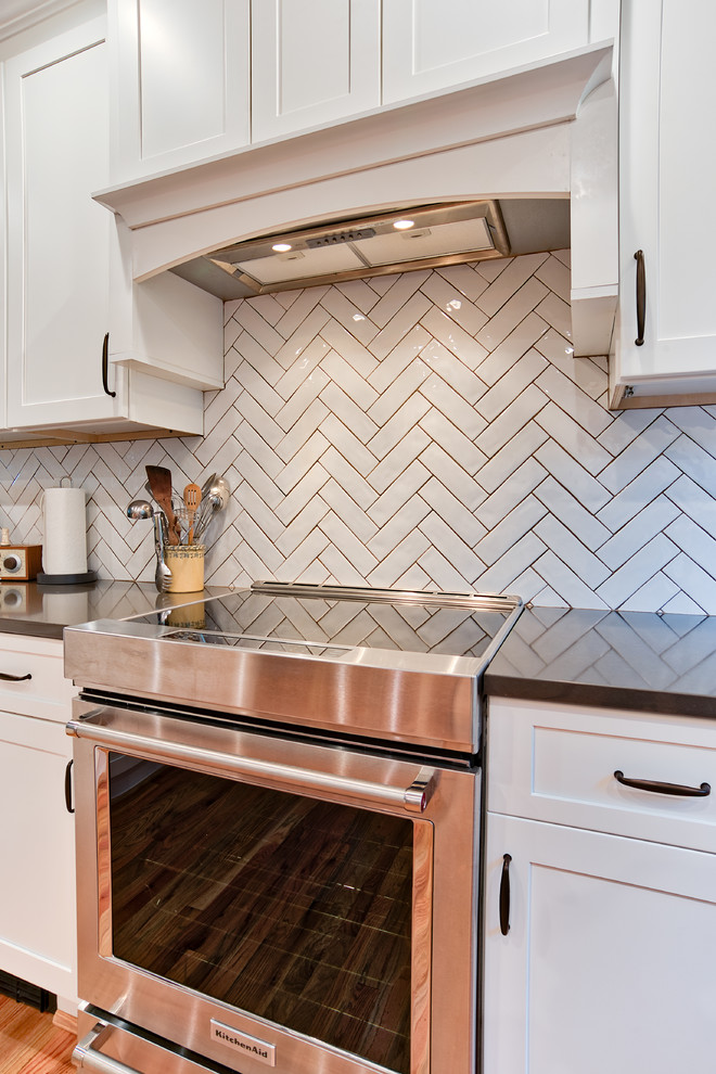 Inspiration for a mid-sized transitional u-shaped eat-in kitchen in Philadelphia with shaker cabinets, white cabinets, glass benchtops, white splashback, subway tile splashback, light hardwood floors, a peninsula, multi-coloured floor, brown benchtop, an undermount sink and stainless steel appliances.