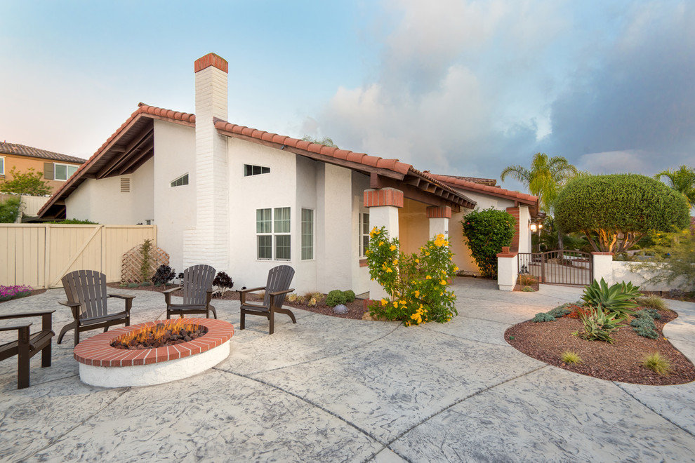 This is an example of an expansive contemporary one-storey stucco white house exterior in San Diego with a gable roof, a tile roof and a red roof.