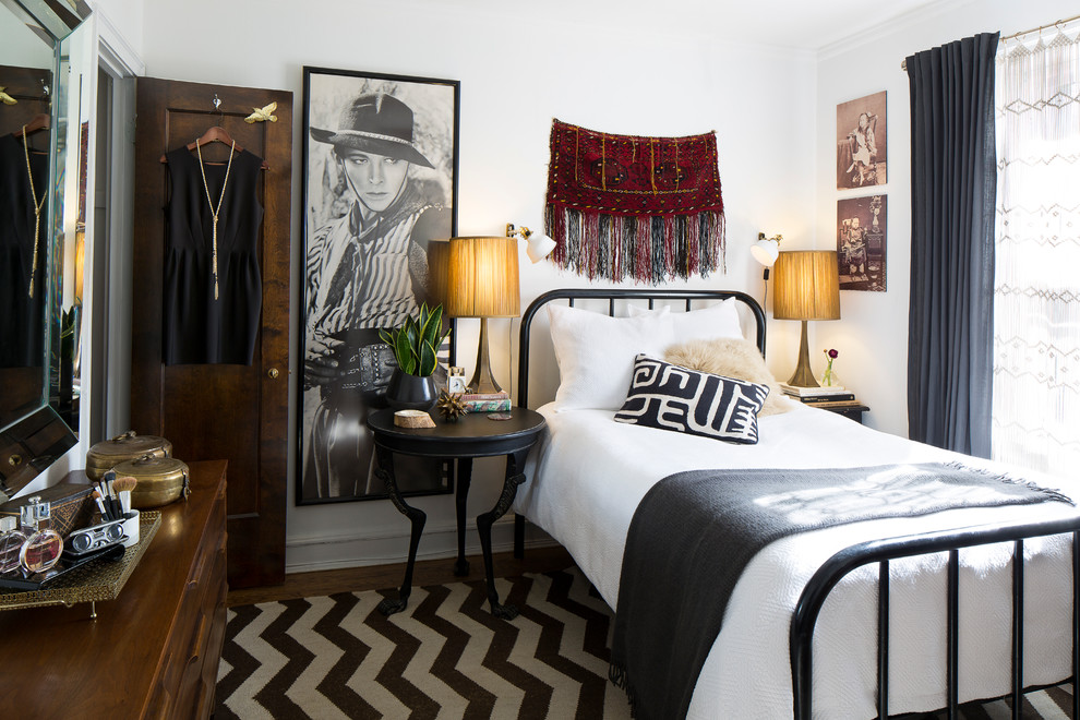 Eclectic bedroom in Chicago with white walls and dark hardwood floors.