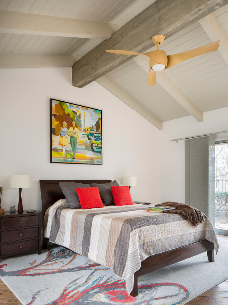 This is an example of a mid-sized transitional master bedroom in Other with white walls, medium hardwood floors, no fireplace and brown floor.