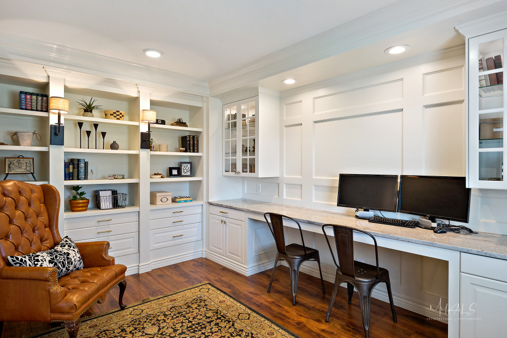 Photo of a mid-sized traditional home office in Salt Lake City with a library, white walls, dark hardwood floors, a built-in desk, brown floor and panelled walls.