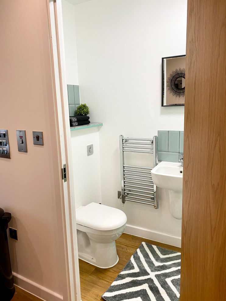 This is an example of a small contemporary powder room in Other with blue walls, laminate floors and orange floor.
